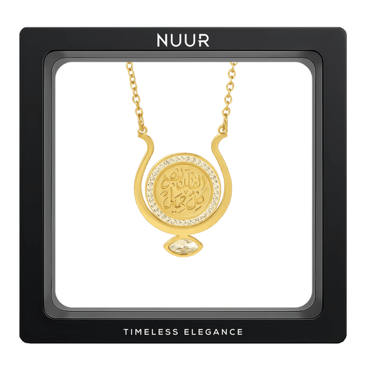 NUUR Qalb gold medallion necklace with a zircon halo and marquise stone in a black display frame
