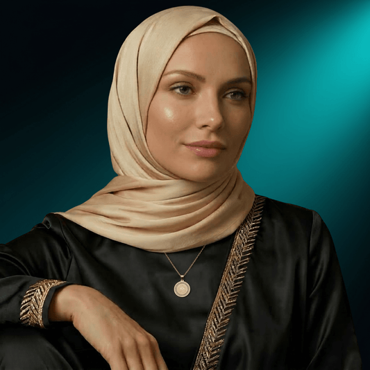 Woman in a hijab wearing the NUUR Ayatul Kursi gold medallion necklace, front view